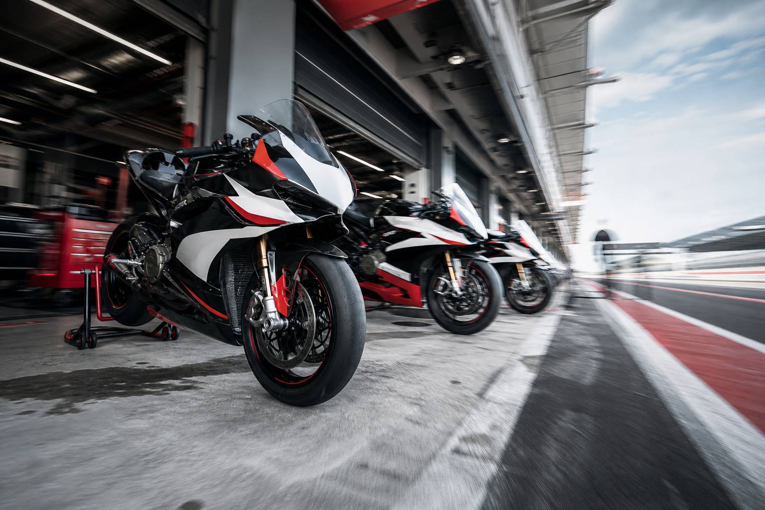 Paddock MotoGP avec motos de course garées dans les stands