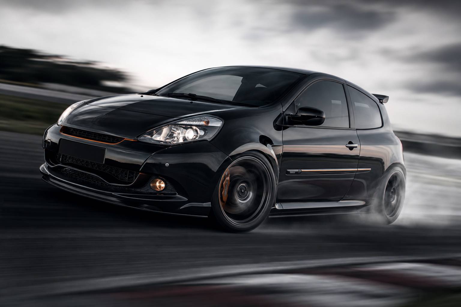 Renault Clio RS en action sur circuit avec dérive et fumée de pneus
